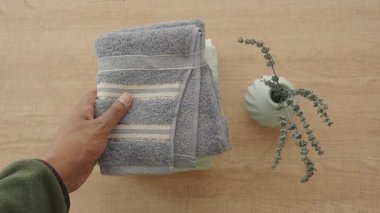 Katlanmış havlular ve küçük bir bitki düzenli ve davetkar bir banyo alanı oluşturur..