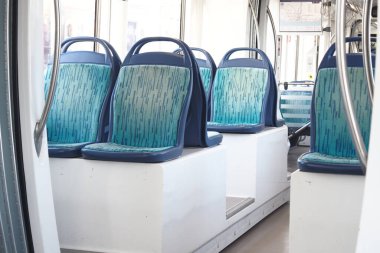 Boş koltukları olan bir toplu taşıma aracının temiz ve modern iç mekanı.