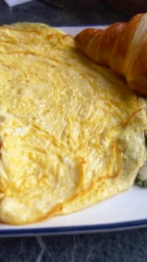 Yumuşak bir omlet ve tereyağlı kruvasan içeren lezzetli bir kahvaltıda iyi eğlenceler..