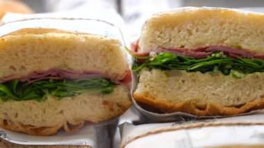 Öğle yemeğinde jambon ve gevrek sebzelerle dolu lezzetli bir sandviçin tadını çıkarın..
