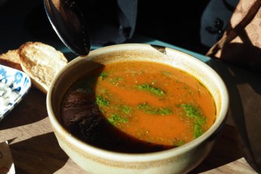 Kızarmış ekmeğin yanında otlarla süslenmiş sıcak bir kase çorba..