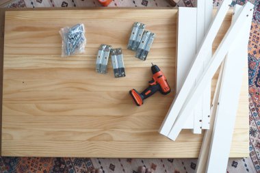 Mobilya montajı için bir yüzeye yerleştirilmiş araç ve malzemeler.