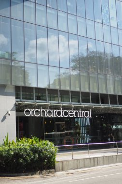 Modern alışveriş merkezinde geniş cam pencereler ve yemyeşil alanlar sergileniyor.