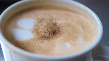 Bir fincan sıcak kahvenin üstü şekerle kaplıdır, cezbedici bir zevk..