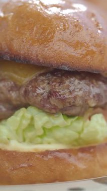 Taze malzemeli lezzetli bir hamburgerin tadını çıkarın..