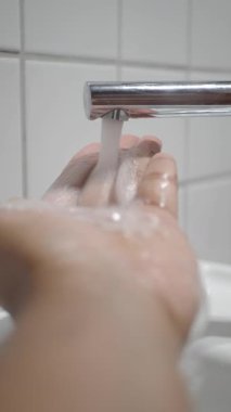 Musluktan akan su, yıkanmak ve hijyen için açık ellere akar..