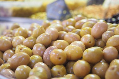 Canlı bir pazarda taze yeşil zeytinler düzgünce düzenlenir..