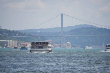 Şehir manzaralı, parlak bir gökyüzünün altındaki Boğaz 'da bir feribot geziniyor..