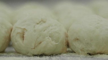 Parlak bir mutfakta taze ekmek ruloları için hamur yoğurup hazırlıyorum..