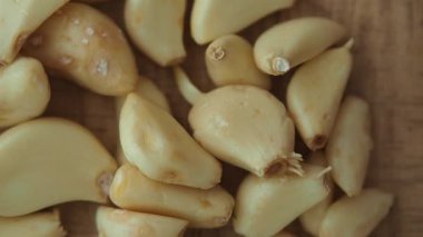 Ahşap bir yüzeye dizilmiş taze soyulmuş sarımsak karanfilleri kullanıma hazır..