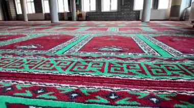 Huzurlu bir dua alanında karmaşık halı desenlerini keşfet..