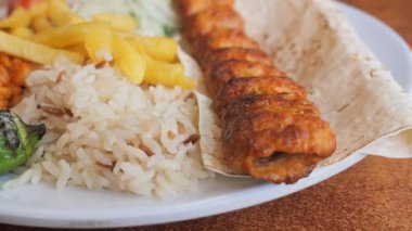Izgara tavuk, pilav, patates kızartması ve sebzeli bir tabağın tadını çıkarın..