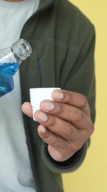 Ağız yıkama sıvısını küçük bir kaba boşaltıyorum. .