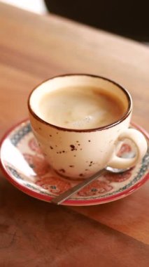 Zarif bir tabakta sıcak bir fincan kahvenin tadını çıkarıyorum..