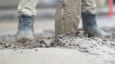 İnşaat işçisi inşaat alanına beton karıştırıyor ve döküyor.