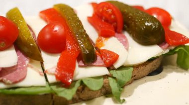 Taze sebze ve etle hazırlanmış canlı bir sandviçin tadını çıkarın..