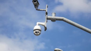 Gözetim sistemleri mavi gökyüzünün altındaki hareketli şehir manzarasını izliyor..