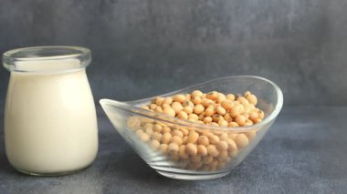 Soybeans are displayed next to fresh soy milk in a clean kitchen.
