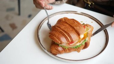 Taze kruvasan sandviçin tadını çıkarıyorum. Sebze ve peynirli..