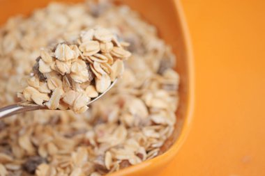 Bir kaşık dolusu yulaf kuru malzemelerle dolu bir kaseden kaldırılır..