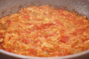 Taze domates ve yumurta sobanın üzerinde lezzetli bir tabakta harmanlanır..