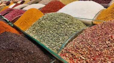 Renkli baharat yığınları bir market tezgahında canlı bir görüntü yaratır.