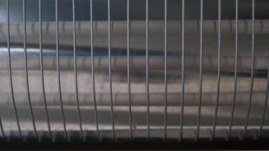 Yakın çekim görüntüsü metal ızgaralı bir cihazda ısıtma elementlerini yakalar.