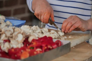 Renkli sebzeler hazırlanmak için sıralarını beklerken eller mantar doğruyor..