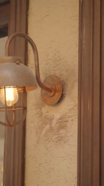 Sıcak bir ışık eski bir duvardaki kırsal bir fenerden parlıyor..