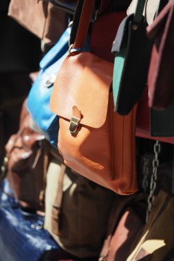 Deri çantalar farklı renklerde. Dışarıdaki bir markette asılı duruyor..