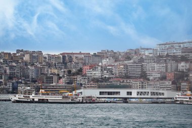 Limanda feribotlar dinleniyor ve arka planda kentsel binalar var..