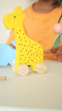 Bir çocuk oynarken parlak sarı bir zürafa oyuncağıyla karşılaşır..