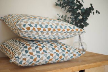 Ahşap bir yüzey üzerinde yeşil renkli geometrik dekoratif yastıklar..