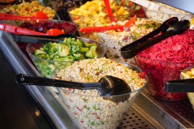 Müşteriler açık büfedeki çeşitli canlı salata ve malzemeler arasından seçim yaparlar..