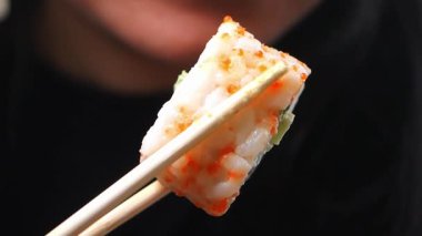 Canlı bir lokantada yemek çubuklarıyla taze suşinin tadını çıkarıyorum..