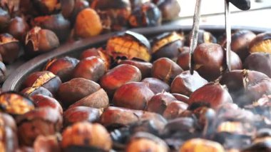Açık hava pazarında kestanelerin kızarmasını izleyin..
