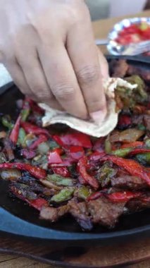 Arkadaşlar taze malzemelerle yapılan fajitaların tadını çıkarmak için toplanır..