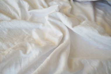 Beyaz kumaş nazikçe serilmiş, pürüzsüz dokusunu ve kıvrımlarını sergiliyor.