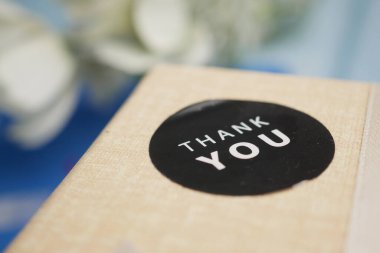 Üzerinde siyah bir teşekkür etiketi olan küçük bir paket..