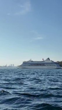 Büyük bir yolcu gemisi güneşli bir günde sakin sularda zarifçe hareket eder..