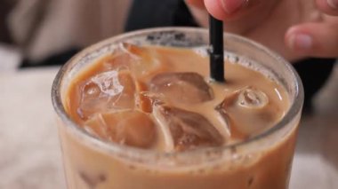 İçi buz dolu serinletici bir buzlu kahve yudumluyorum.