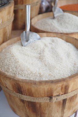 Tahta konteynırlar taze hasat edilmiş pirinci üstünde kürekle tutar..