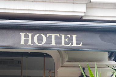 Canlı bir şehir ortamında, girişte bir otel tabelası asılı..