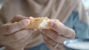 Bir insan büyüleyici bir kafede otururken yeni pişmiş bir pastanın tadını çıkarır..