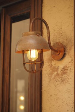 Eski bir duvar ışığından gelen sıcak bir parıltı kırsal bir ortamı güçlendirir..