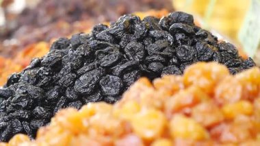 Kalabalık bir pazarda, canlı gölgelerde çeşitli kurutulmuş meyveleri keşfedin..