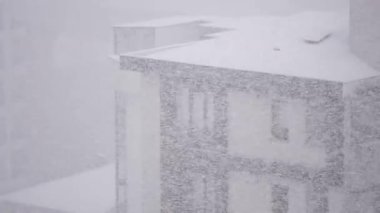 Şiddetli kar, kış fırtınası sırasında şehirdeki binaların üzerine yağar..