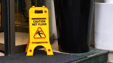 Uyarı levhası, binanın girişindeki ıslak kattaki ziyaretçileri uyarır..