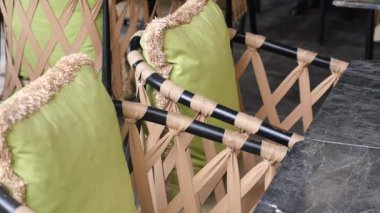 Yeşil yastıklı sandalyeler parlak siyah bir masanın etrafına dizilir..