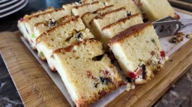 Taze pişmiş meyveli kek dilimleri zevk için ahşap bir tahtaya dizilmiştir..